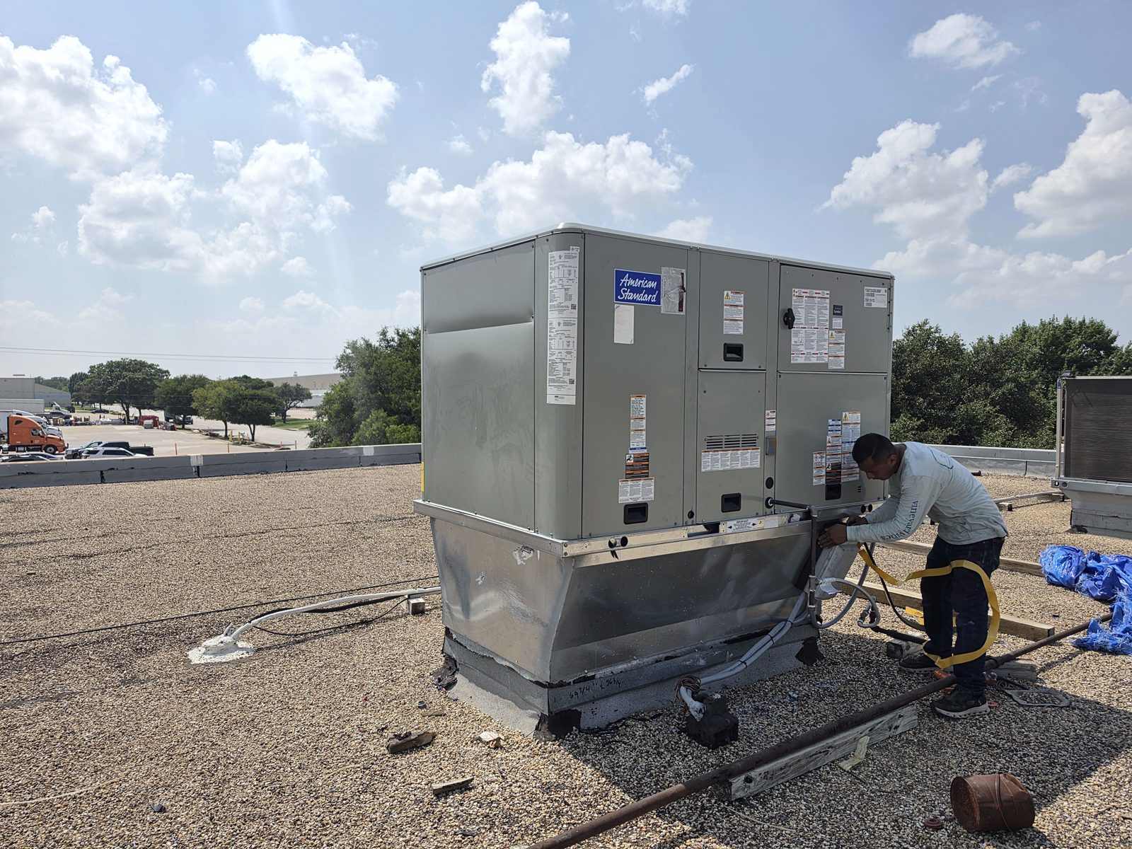Cyclone Heating & Air technician servicing a rooftop package unit
