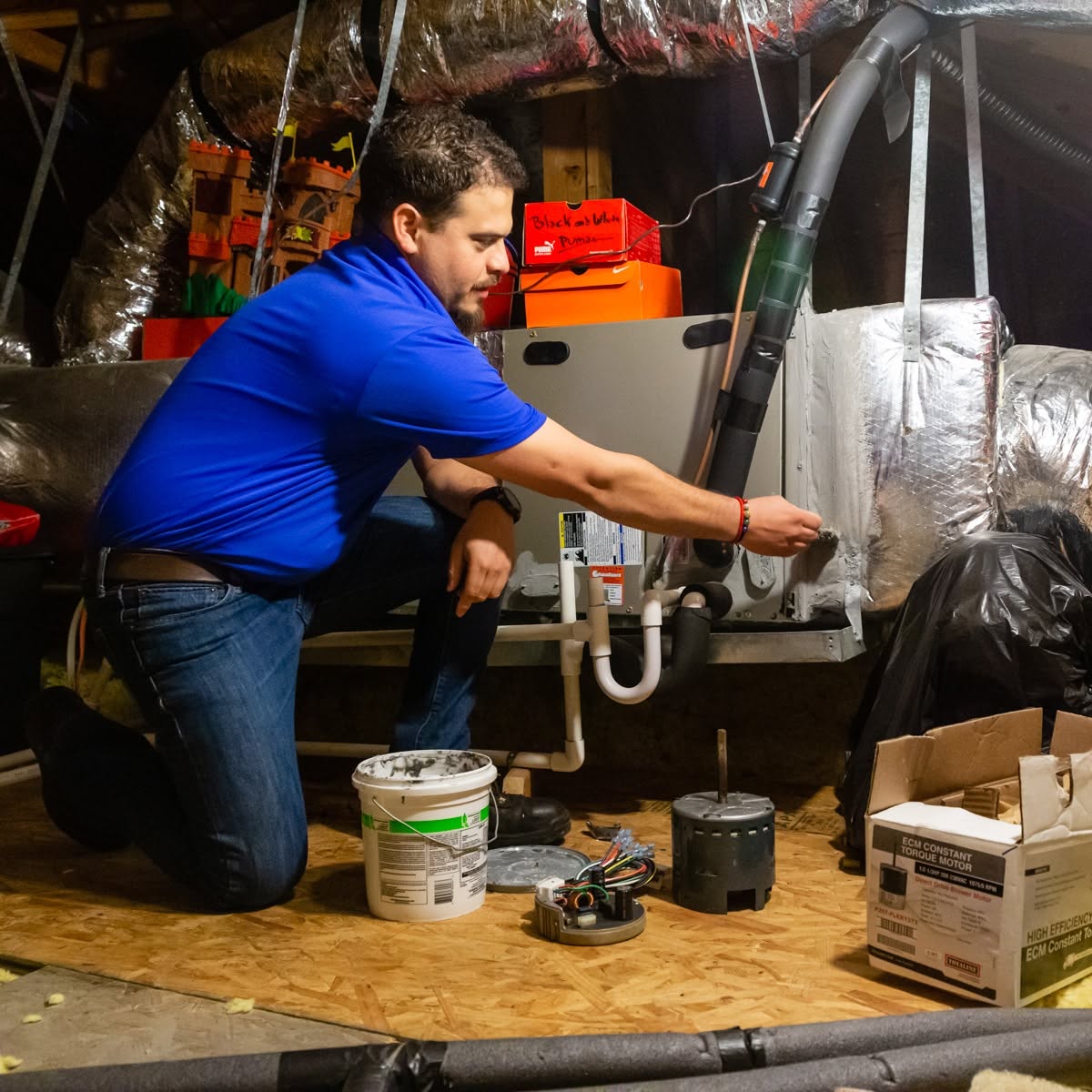 Cyclone Heating & Air technician working on an attic air handler and furnace