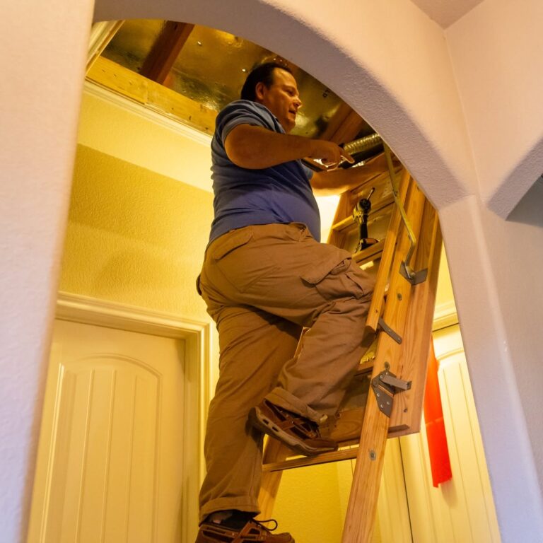 Cyclone technician climbing into an attic to service the air handler