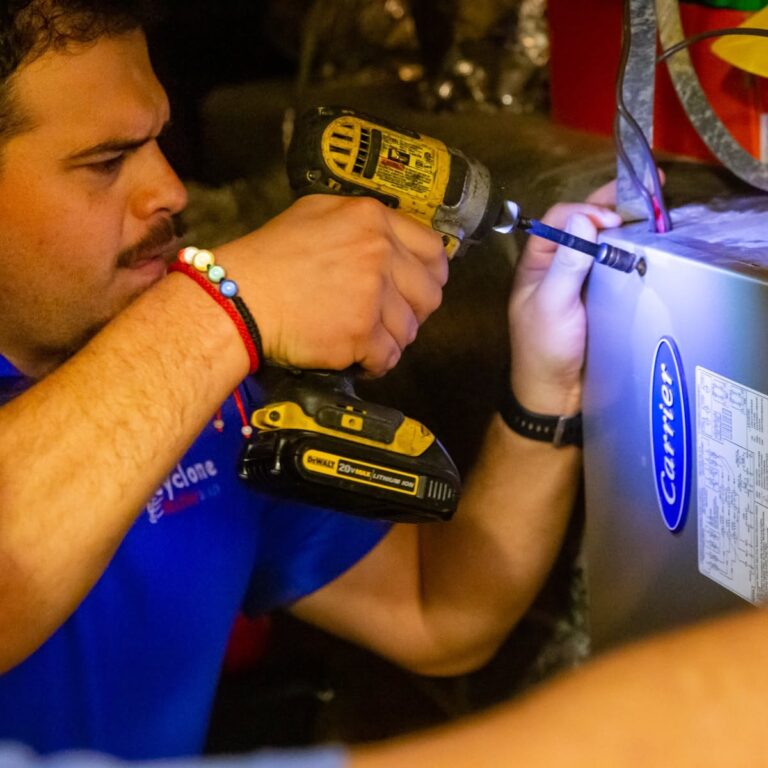 Cyclone technician making a repair inside an HVAC unit